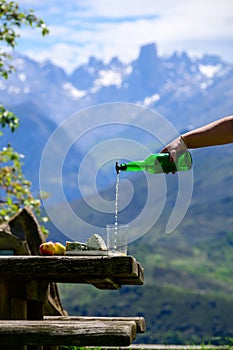 Pouring from high height of natural Asturian cider made fromÂ fermented apples, Asturian cabrales cow blue cheese with view on